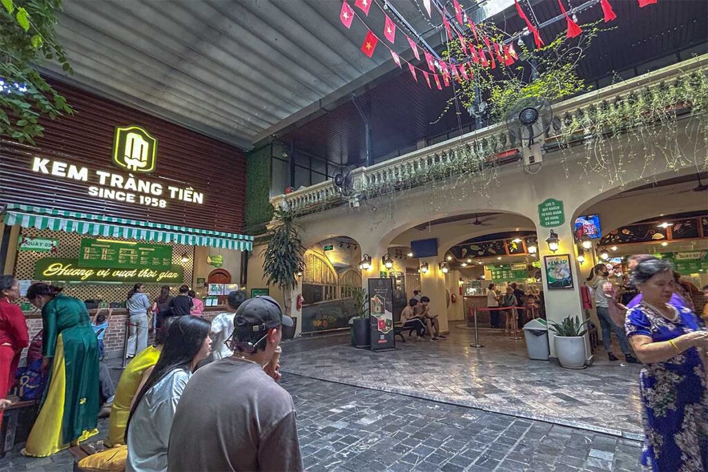 Inside Tran Tien Ice Cream with Vietnamese dressed up to take photos inside the iconic ice cream shop of Hanoi