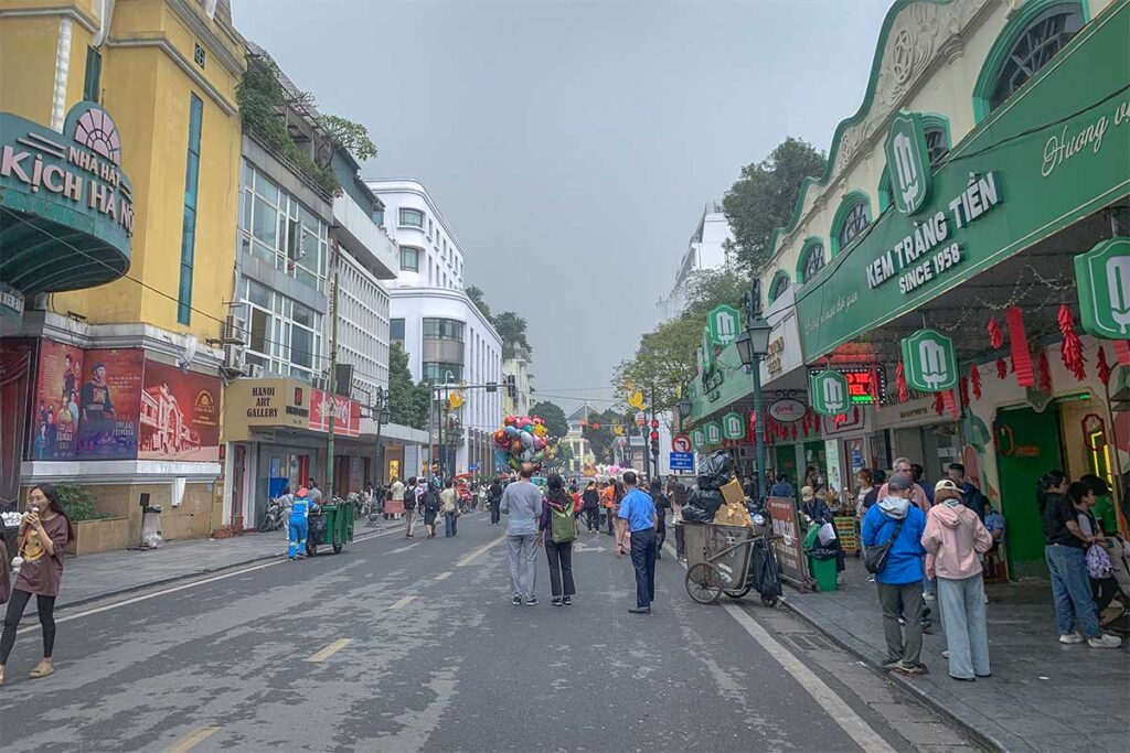 Trang Tien Ice Cream shop and in the far distance on the end of the street glimpse of Hanoi Opera House