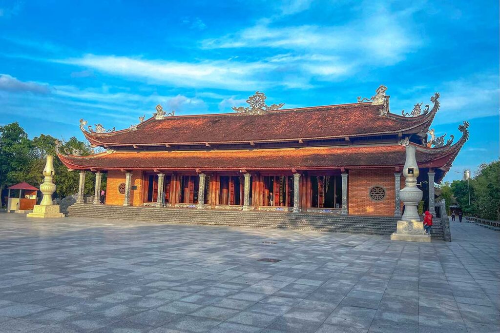 Exterior of the main hall at Truc Lam Phuong Nam Zen Monastery in Can Tho, with wooden doors and tiled roof.