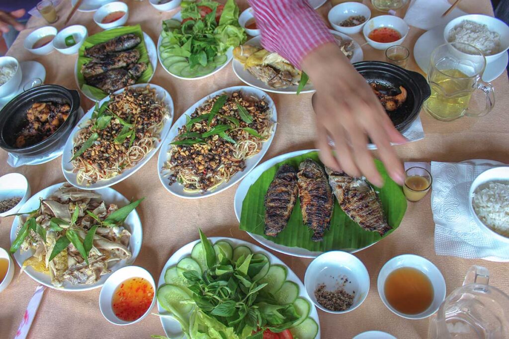 A family style dinner with different local dishes served in a simple setting at U Minh Ha National Park