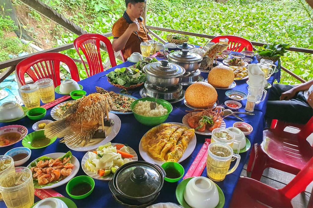 Traditional Mekong Delta lunch on Unicorn Island with elephant ear fish, prawns, hotpot, and Vietnamese specialties served at a riverside restaurant.