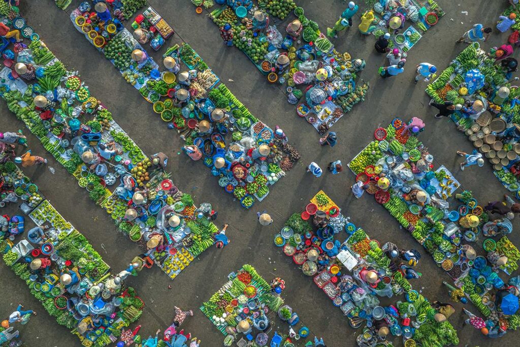 Drone view of Vi Thanh Market in Hau Giang with orderly rows of squat-down vendors selling local produce