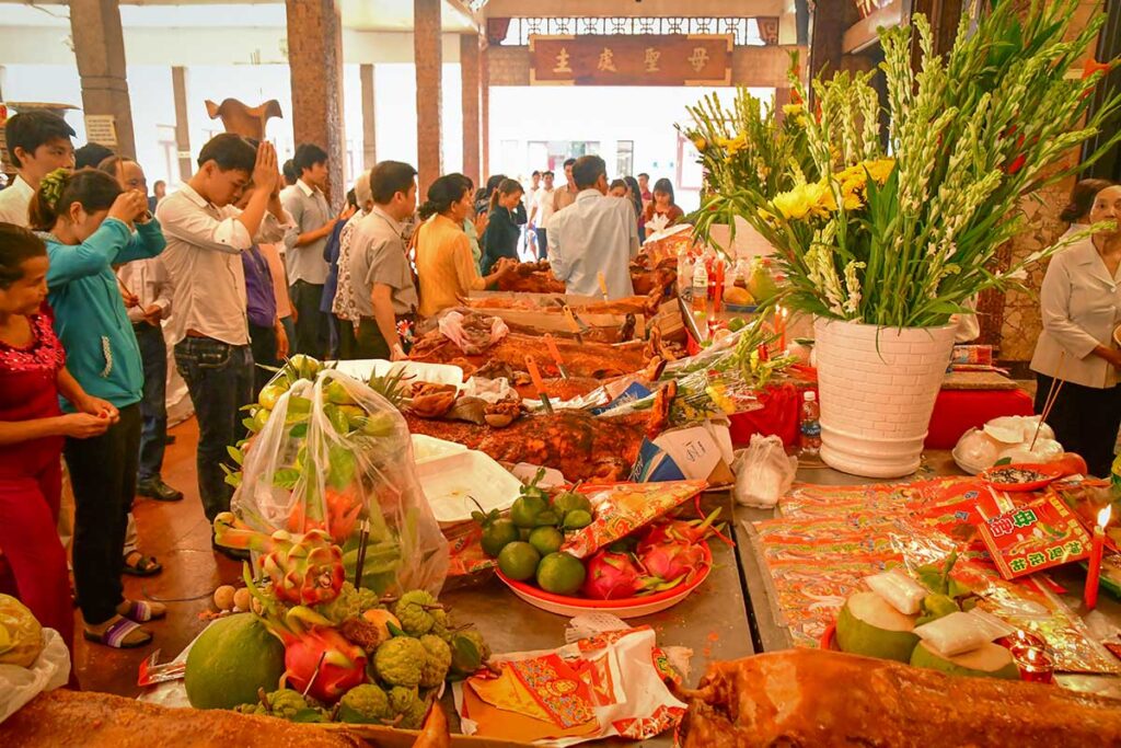 Tables filled with fruit, incense, and whole roasted pigs as offerings during Ba Chua Xu Temple Festival in Chau Doc.