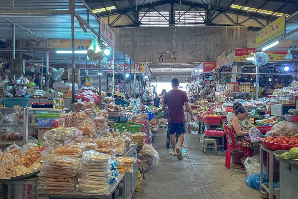 Indoor food stalls at Cai Khe Market in Can Tho with packaged snacks and fresh produce