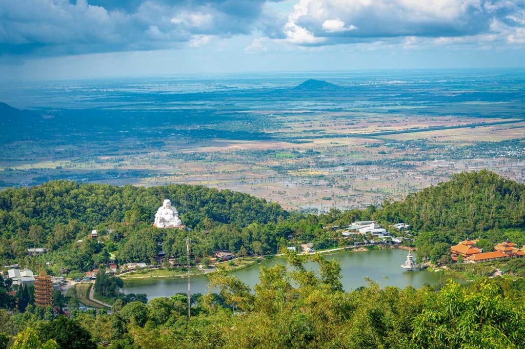 Cam Mountain lake and Buddha statue – Thuy Liem Lake with panoramic view of the Maitreya Buddha statue and temples on Forbidden Mountain in An Giang.