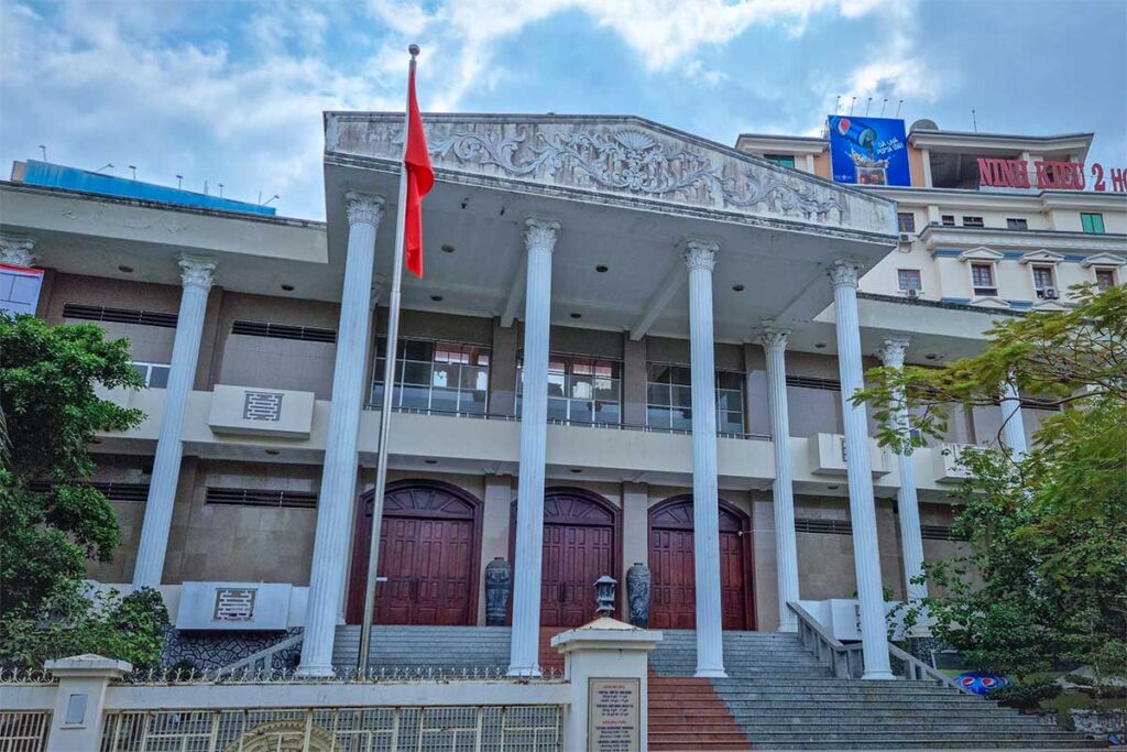 Front entrance of Can Tho Museum in central Can Tho, Vietnam, with columns and national flag.