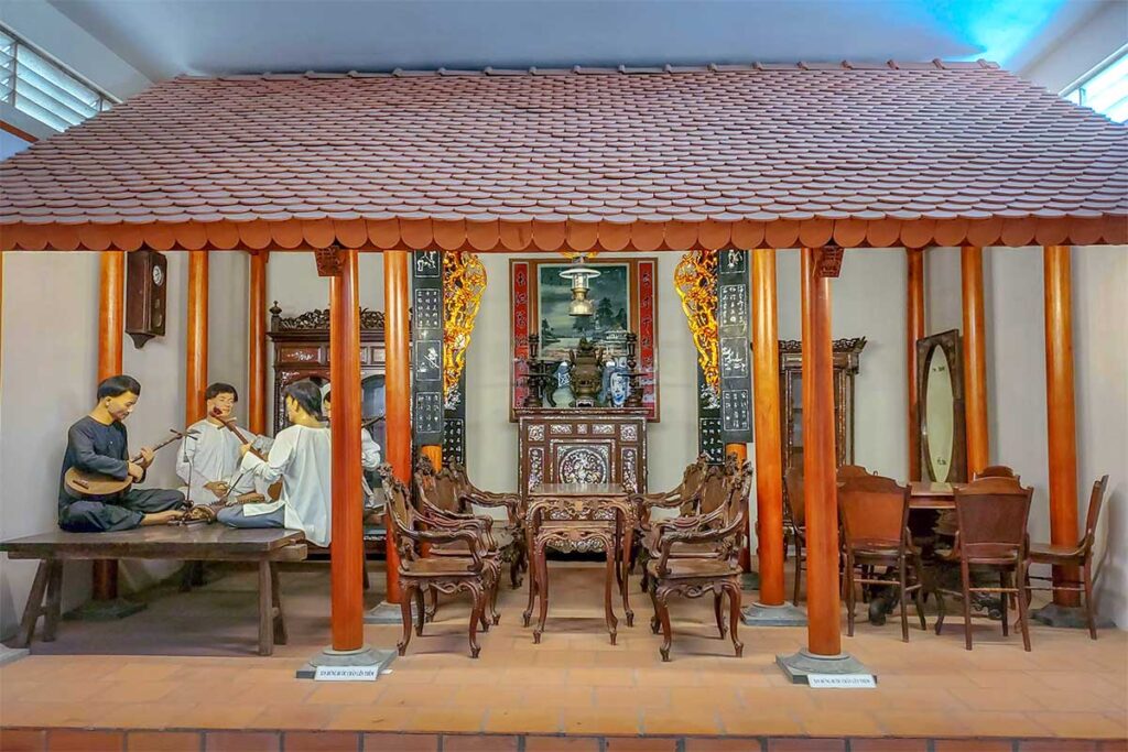 Life-size reconstruction of a traditional southern Vietnamese house with family altar and musicians at Can Tho Museum.