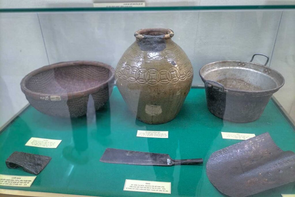 Traditional household tools and ceramic jar on display at Can Tho Museum, representing daily life in the Mekong Delta.