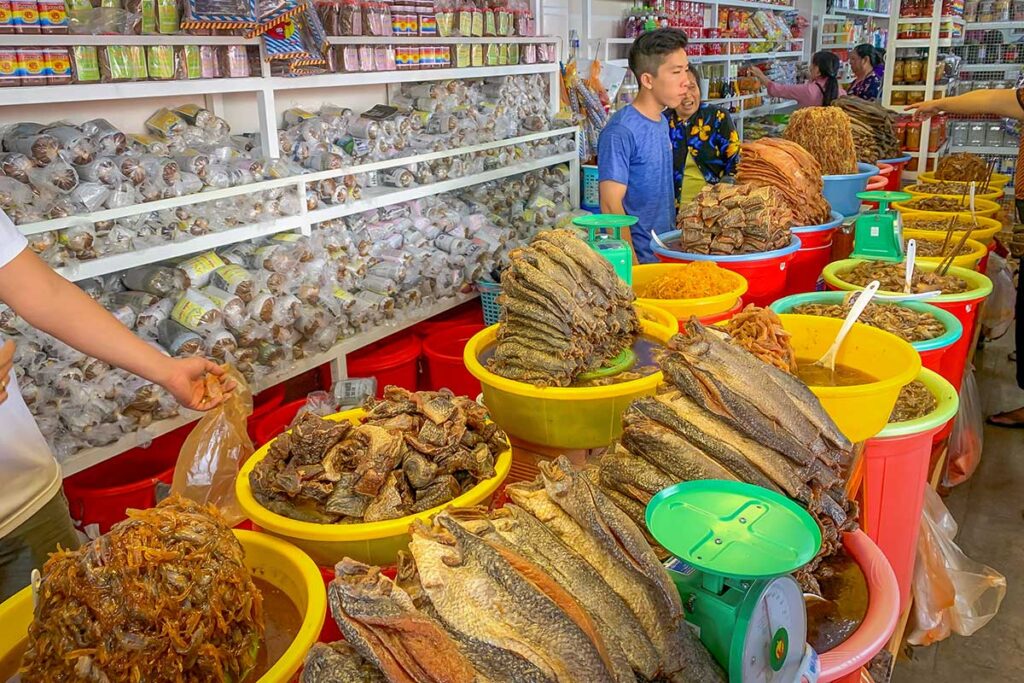 Colorful dried fish and fermented seafood stalls at Chau Doc Market in An Giang, Vietnam, showcasing Mekong Delta food culture and local specialties.