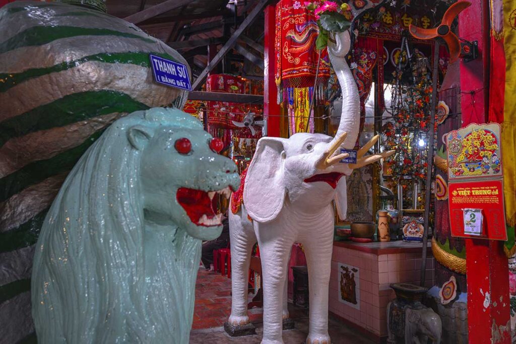 Clay elephant and lion statues inside Clay Pagoda – White six-tusked elephant and guardian lion among other clay works inside the temple.