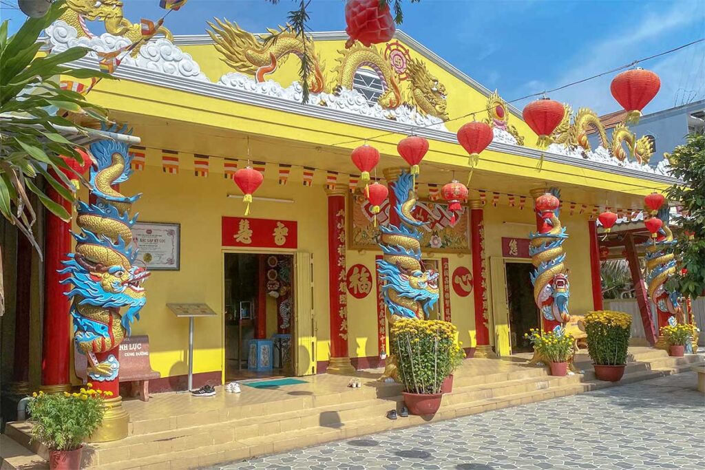 Main hall of Clay Pagoda Soc Trang – Yellow-painted main temple hall with red lanterns and dragon pillars at the entrance.