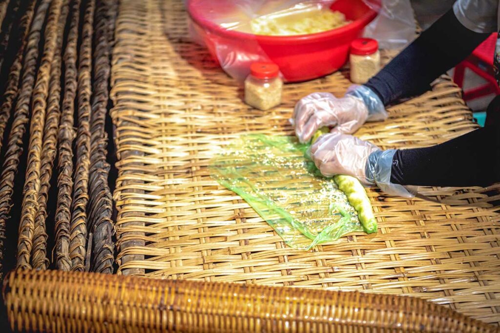 Making traditional southern cakes at Con Son Islet – local woman preparing bánh lá mít with rice flour and coconut