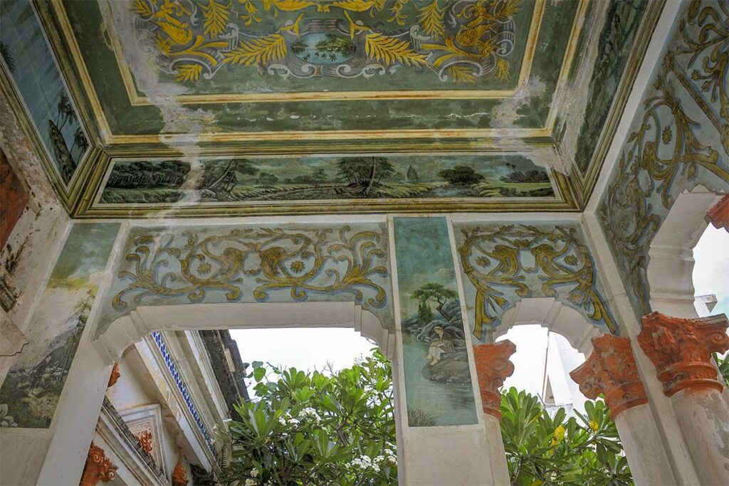 Colorful ceiling and wall murals with nature scenes and floral motifs inside Huynh Ky Ancient House, Tra Vinh.