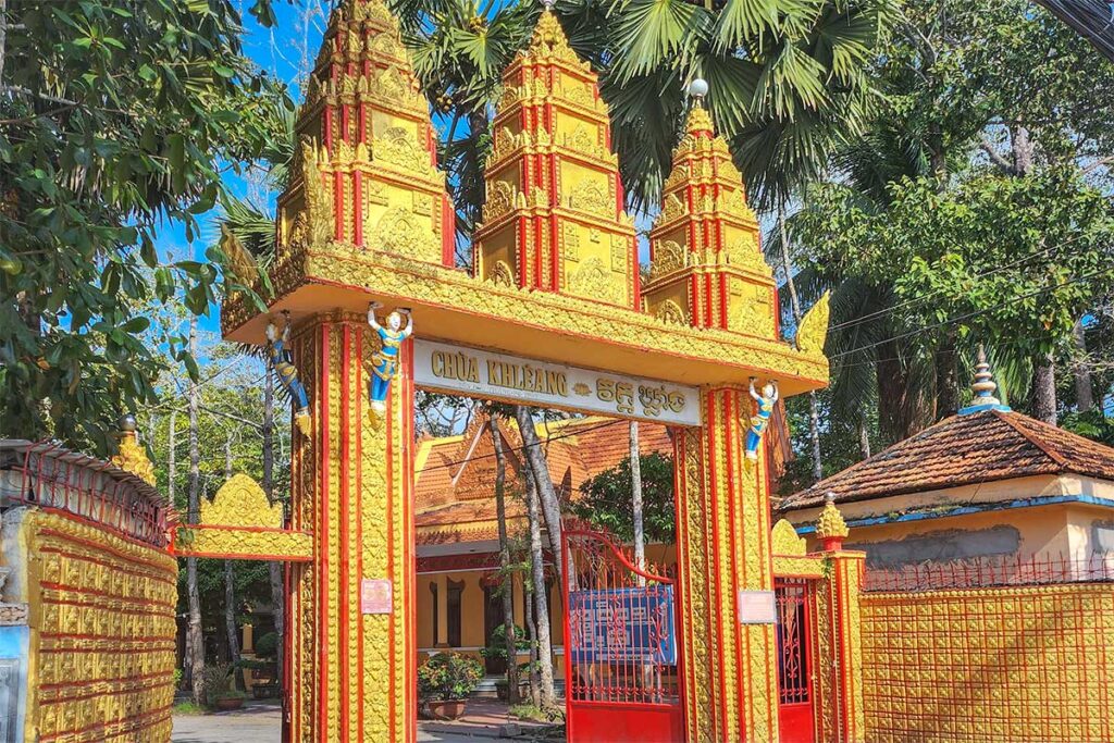 Golden Khmer stupa at Kh’leang Pagoda in Soc Trang, built on a raised platform with staircases and intricate carvings.