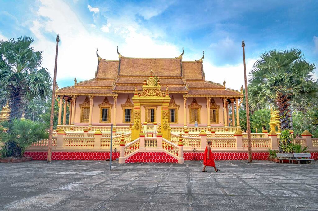 Front view of the main hall at Kh’leang Pagoda in Soc Trang, with a lone monk walking across the courtyard.