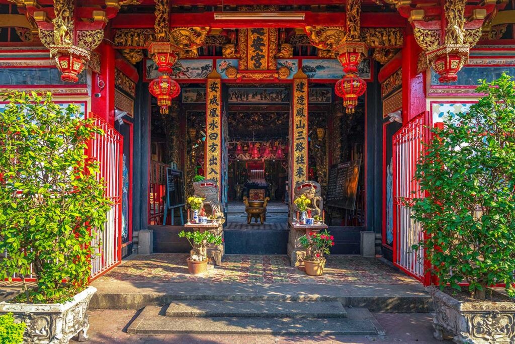 Entrance of Kien An Cung Temple in Sa Dec, Dong Thap with red lanterns, Chinese calligraphy, and ornate golden carvings
