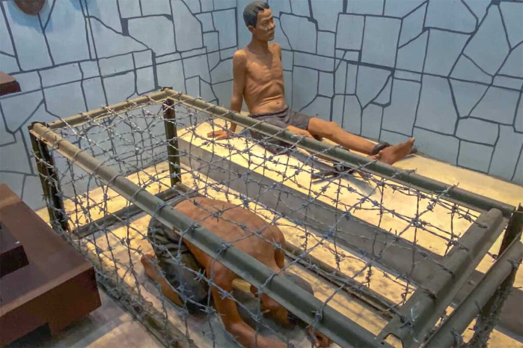 Re-creation of a prison cell with mannequins showing wartime torture methods at Military Zone 9 Museum