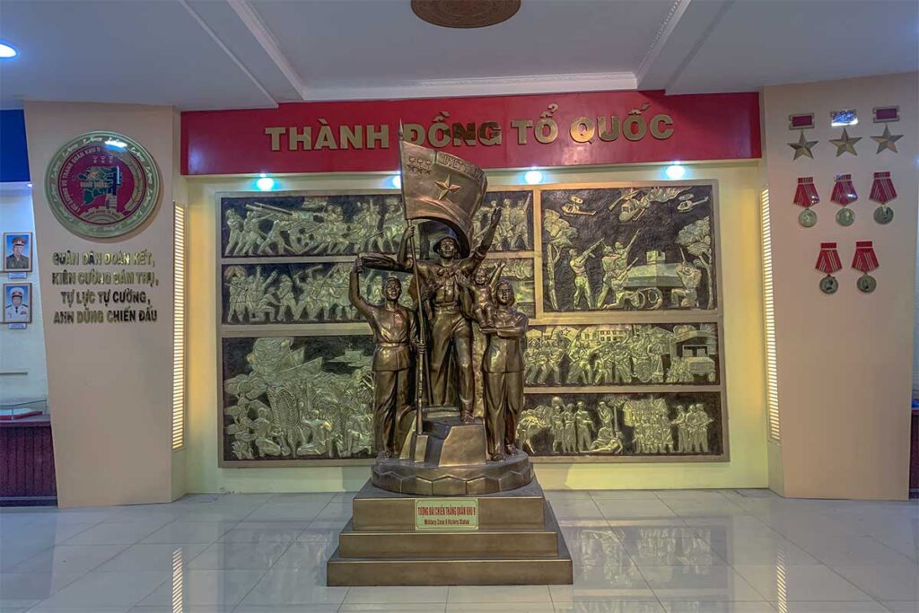 Revolutionary statue and wall relief inside the ceremonial hall of Military Zone 9 Museum in Can Tho