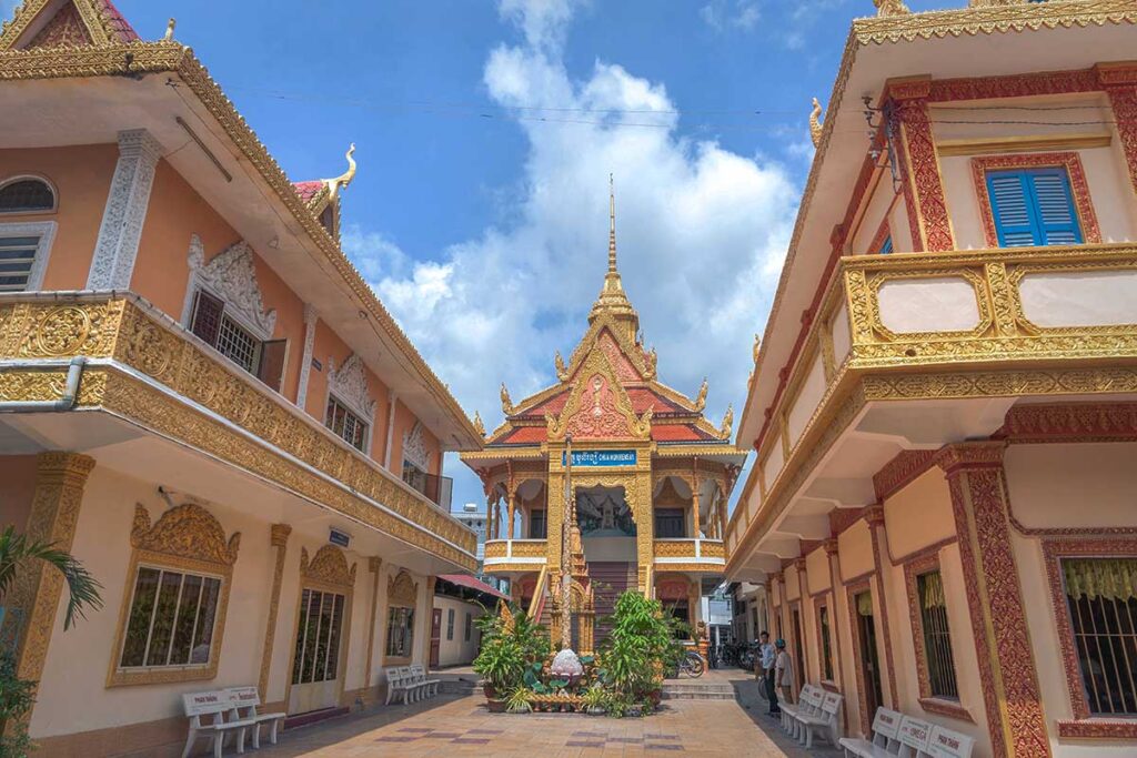 Courtyard and main hall of Muniransay Khmer Buddhist Temple in Can Tho with golden Khmer decorations.