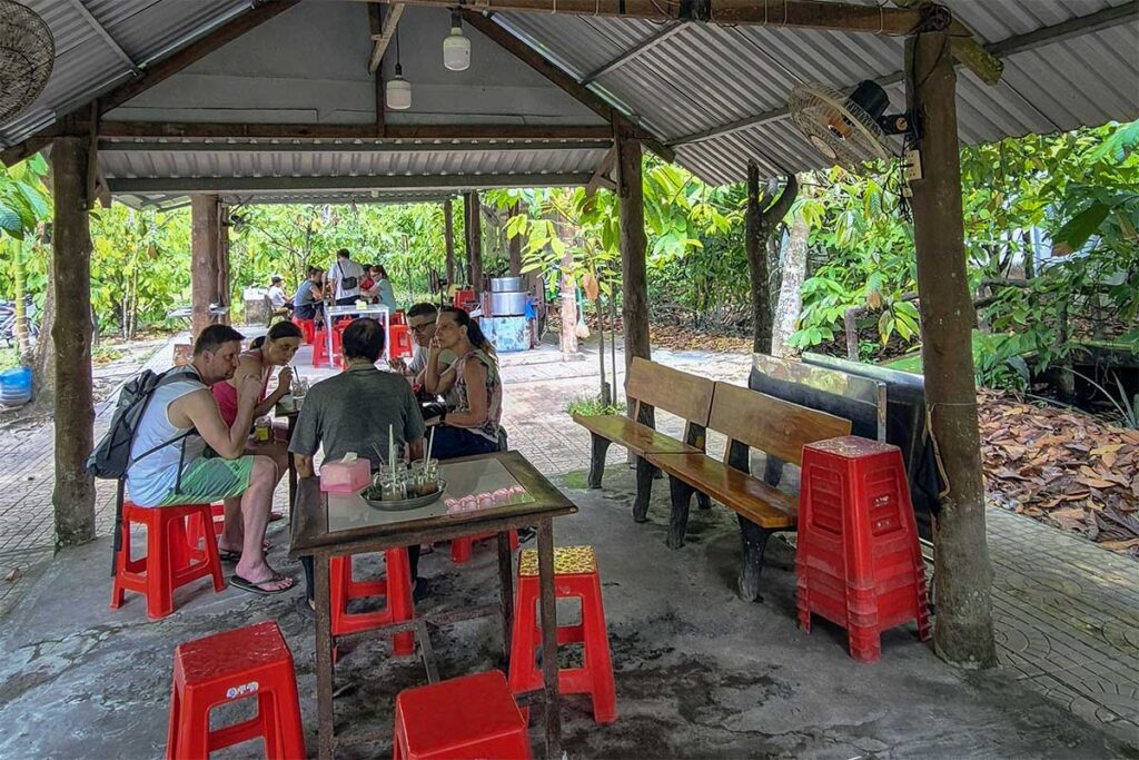 Visitors enjoying cacao drinks at the tasting area of Muoi Cuong Cacao Farm in Can Tho