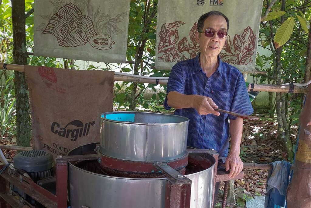 Mr. Muoi Cuong demonstrating the traditional cacao roasting process at his farm in Can Tho