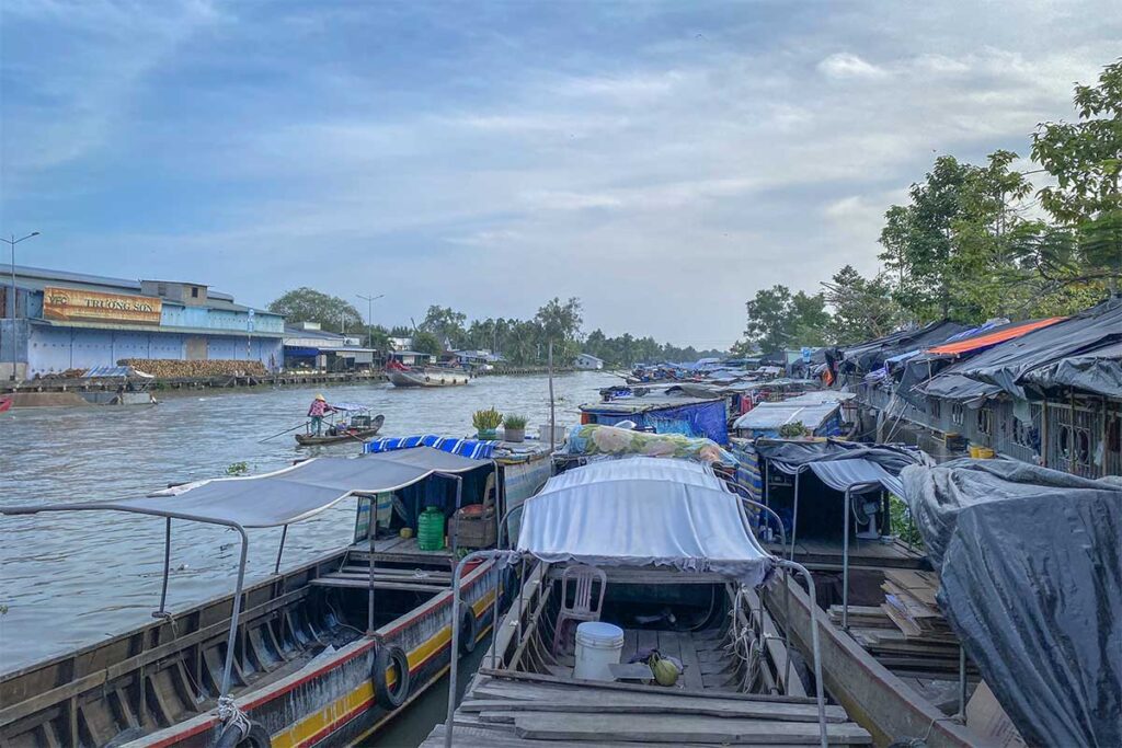 Row of boats docked along Nga Nam canal near the busy riverside town market.