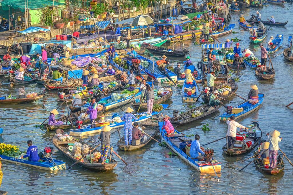Close-up of traders exchanging goods from small sampans at Nga Nam Floating Market in Soc Trang, Vietnam.