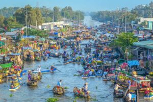 Colorful boats packed with fruits and vegetables crowding Nga Nam Floating Market in Soc Trang Province, Mekong Delta.