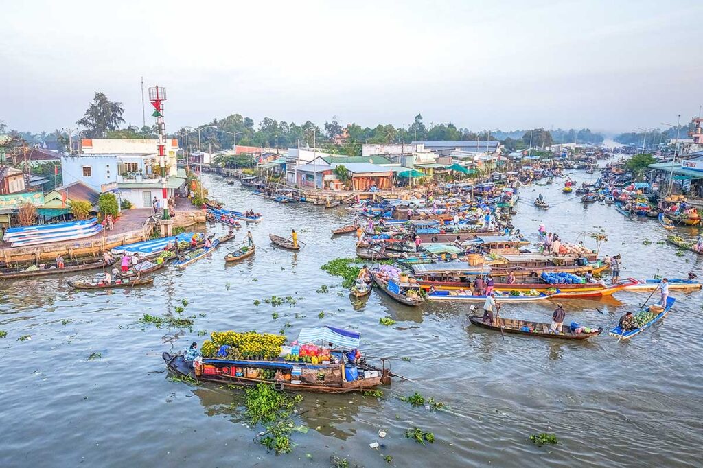 Busy morning scene at Nga Nam Floating Market with trading boats gathering at the five-way canal junction in Soc Trang, Vietnam.
