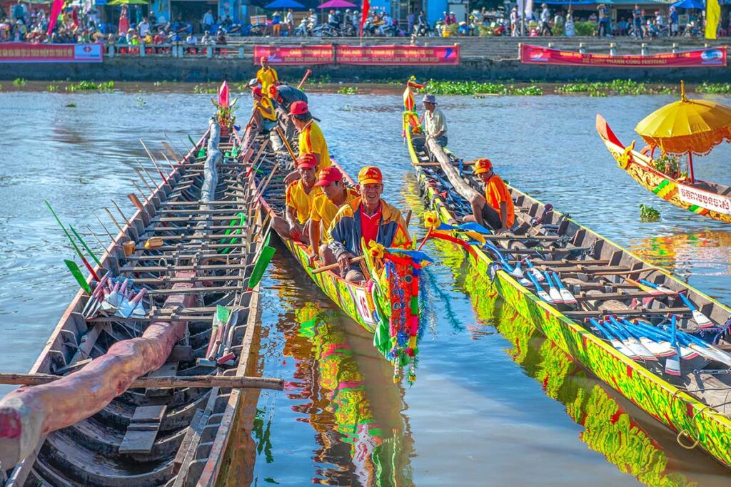 Khmer rowing teams preparing longboats with decorated prows before the Ghe Ngo Boat Race Festival in Soc Trang, Vietnam.