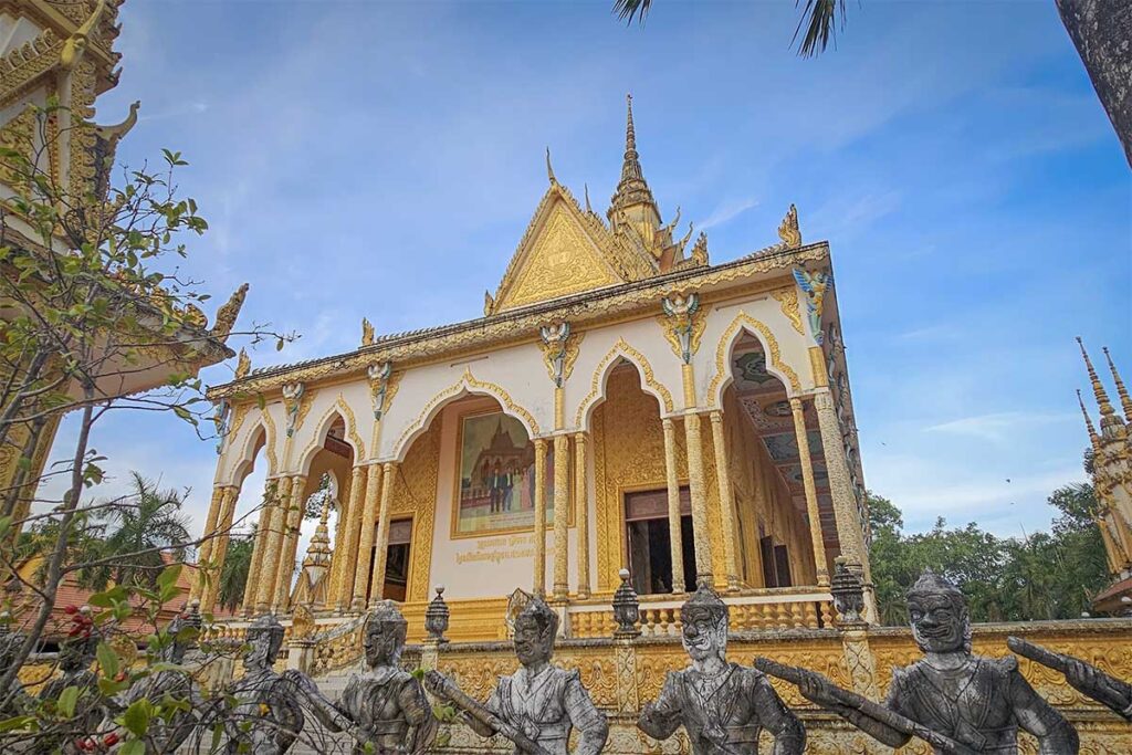 Golden Khmer-style main hall of Nodol Pagoda, Tra Vinh, decorated with statues and reliefs of mythical figures