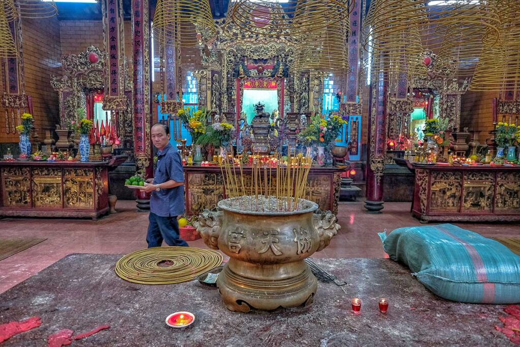 Incense burner and altars filled with offerings inside Ong Pagoda Can Tho