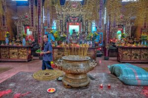 Incense burner and altars filled with offerings inside Ong Pagoda Can Tho