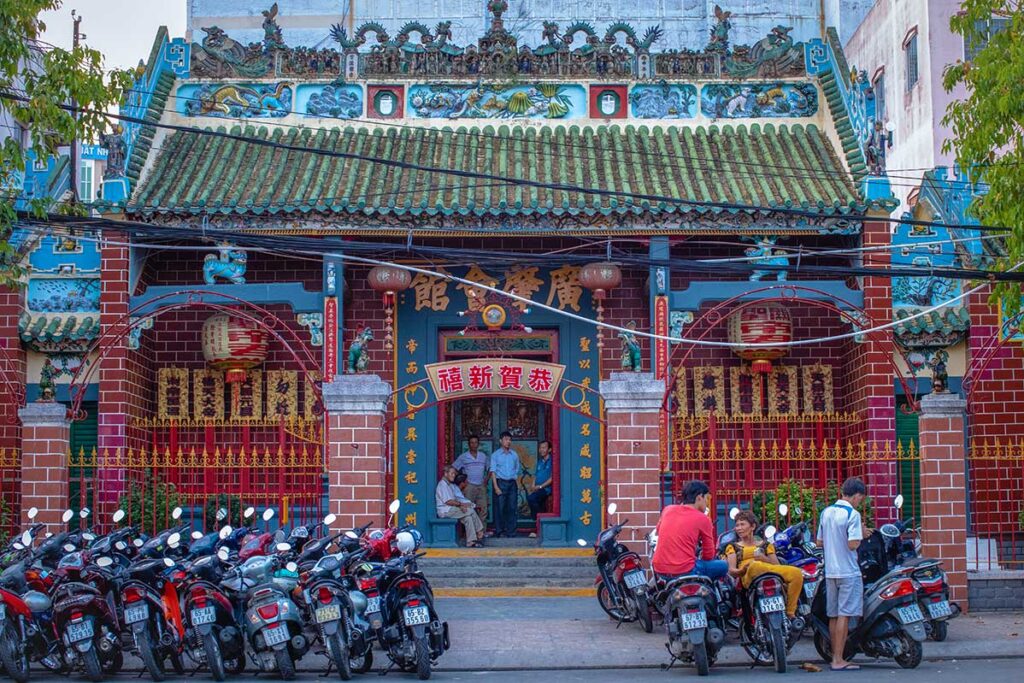 Front façade of Ong Pagoda (Canton Assembly Hall) in Can Tho with tiled roof and motorbikes outside
