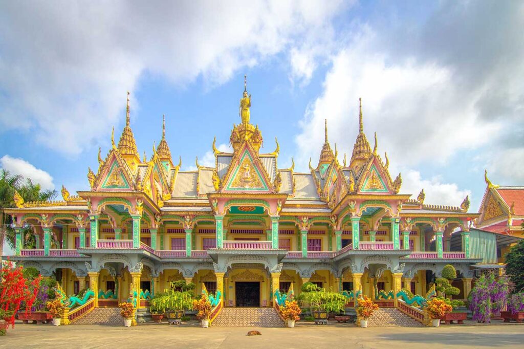 Front view of the colorful Sala hall at Som Rong Pagoda, with Khmer architecture, naga stair railings, and golden roof spires