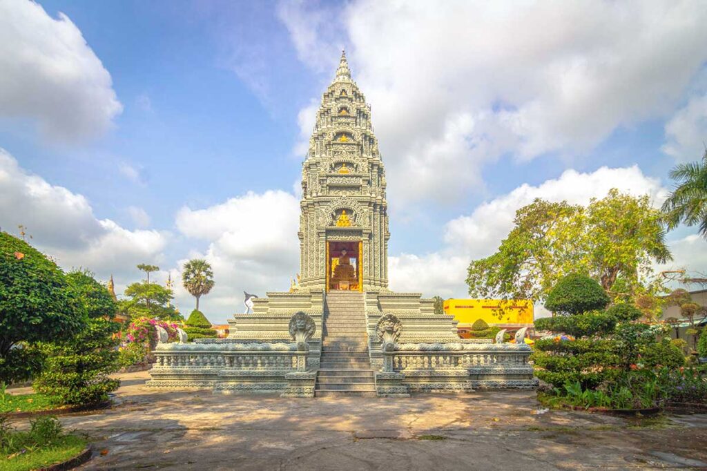 Gray stone stupa at Som Rong Pagoda in Soc Trang, with naga stairways and Khmer carvings, used for keeping monks’ ashes