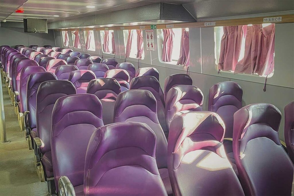 Interior of a Superdong ferry – rows of purple cushioned seats with air-conditioning for the Ha Tien to Phu Quoc route.