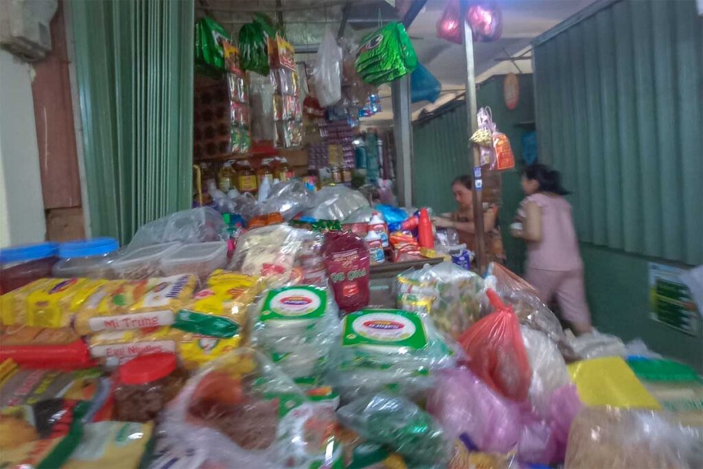 Dry goods and packaged food section of Tan An Market Hoi An with noodles, sauces, and household supplies