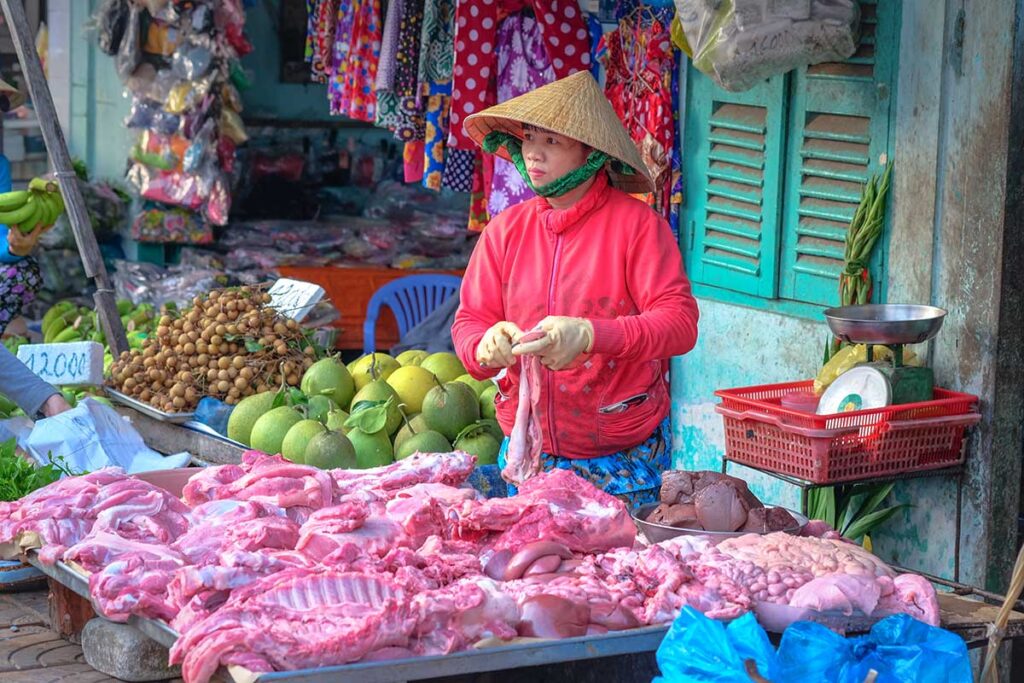 Fruit and meat stalls at Xuan Khanh Market in Can Tho with vendors and colorful produce