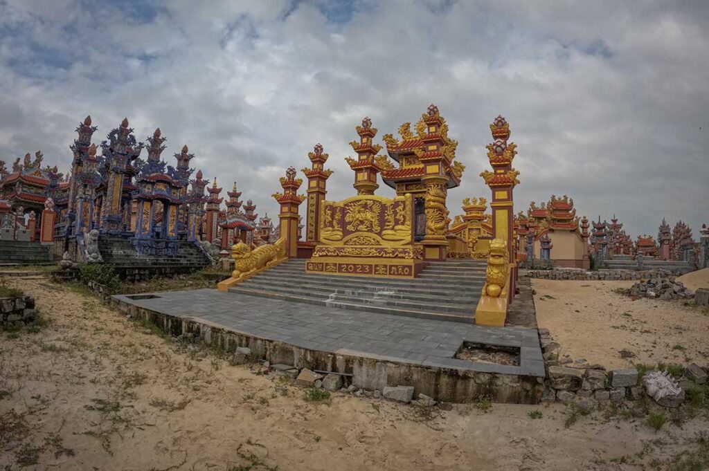 Brightly decorated mausoleums with golden dragons and bold patterns inside An Bang Cemetery, showcasing the unique blend of Vietnamese, Buddhist, and royal Hue influences.