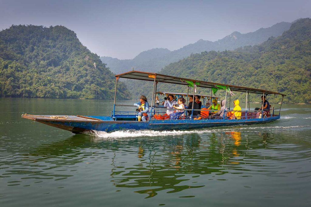 Authentic Ba Be Lake tours by Local Vietnam | exploring Ba Be Lake by boat surrounded by limestone mountains and jungle