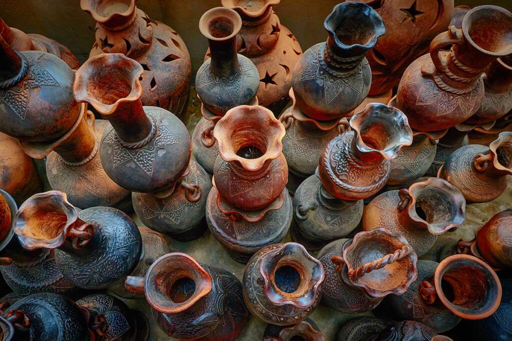 Top view of decorative Cham pottery vases with intricate designs and reddish-brown hues in Bau Truc Pottery Village.