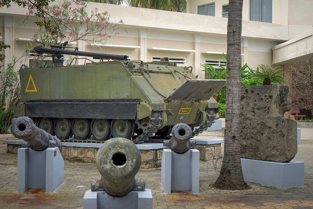 War relics outside Binh Dinh Museum in Quy Nhon, including a military vehicle and cannons.