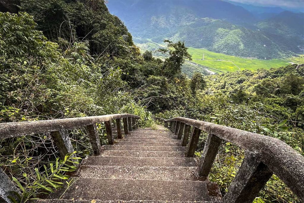 Trailhead to Da Bia Mountain – Stone stairway leading through dense forest towards the summit of Da Bia Mountain, starting point of the hike from near Ca Pass.