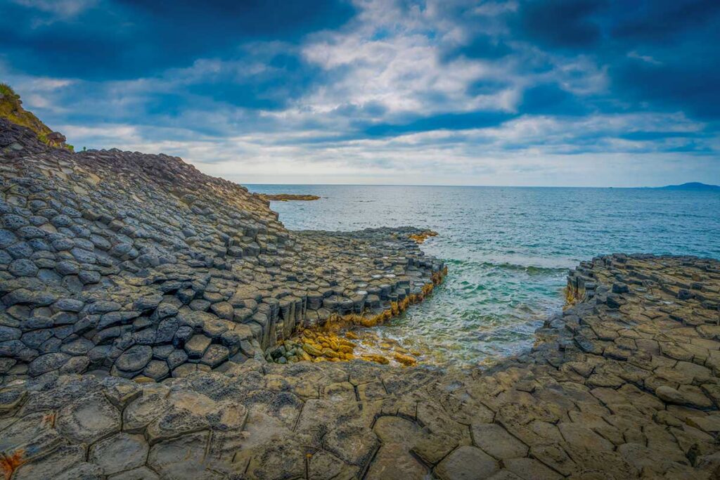 Basalt stone plates rising from the sea at Da Dia Reef, a unique volcanic formation in Phu Yen Province.