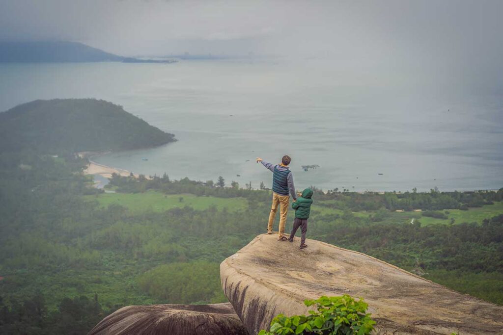 Father and son admiring ocean views from Hai Van Pass near Da Nang