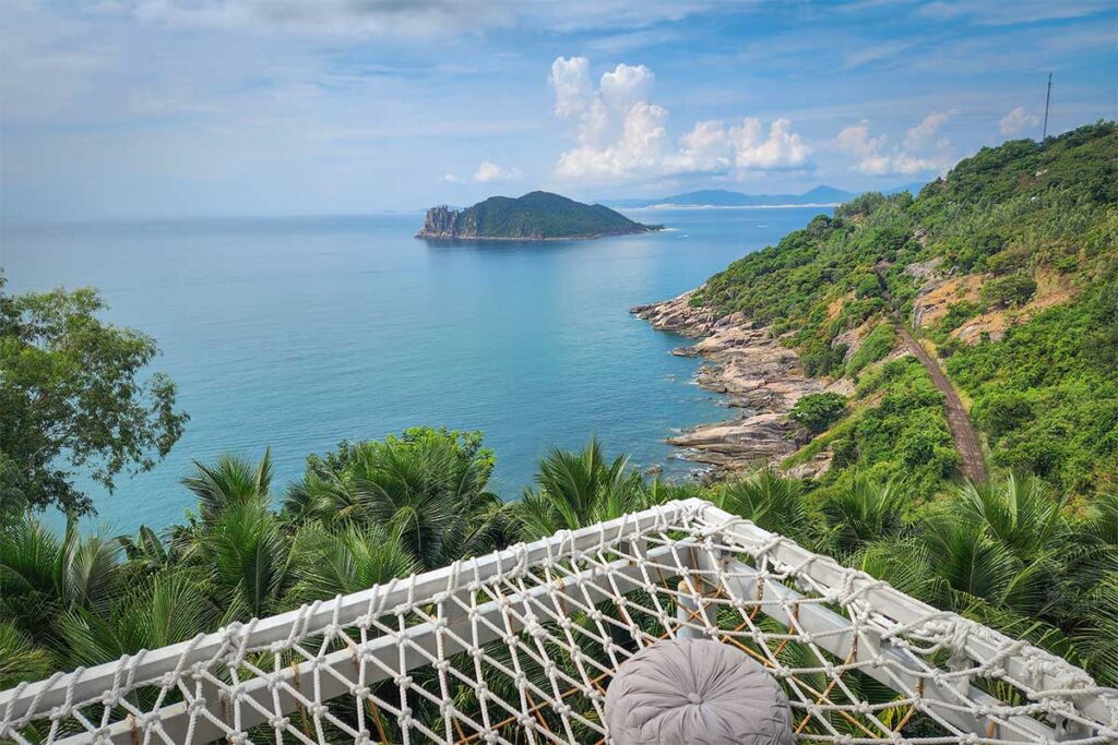 Railway track along Deo Ca Pass – Railway line running through the coastal cliffs south of Deo Ca Pass, seen from a café viewpoint above the tracks and the sea.