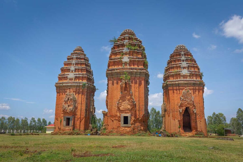 Frontal view of the three Duong Long Cham Towers aligned north–south on a low hill in Tây Sơn District, Binh Dinh.