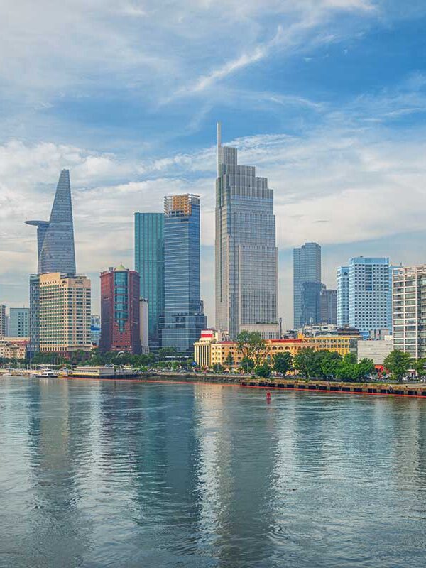 Saigon tours – Local Vietnam | skyline of Ho Chi Minh City with Bitexco Tower and modern riverside buildings seen from the Saigon River