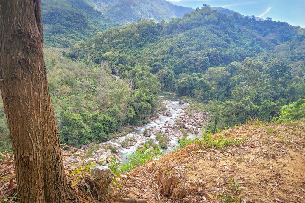 River valley with rocky stream meandering through the forested slopes of Hon Ba Nature Reserve.